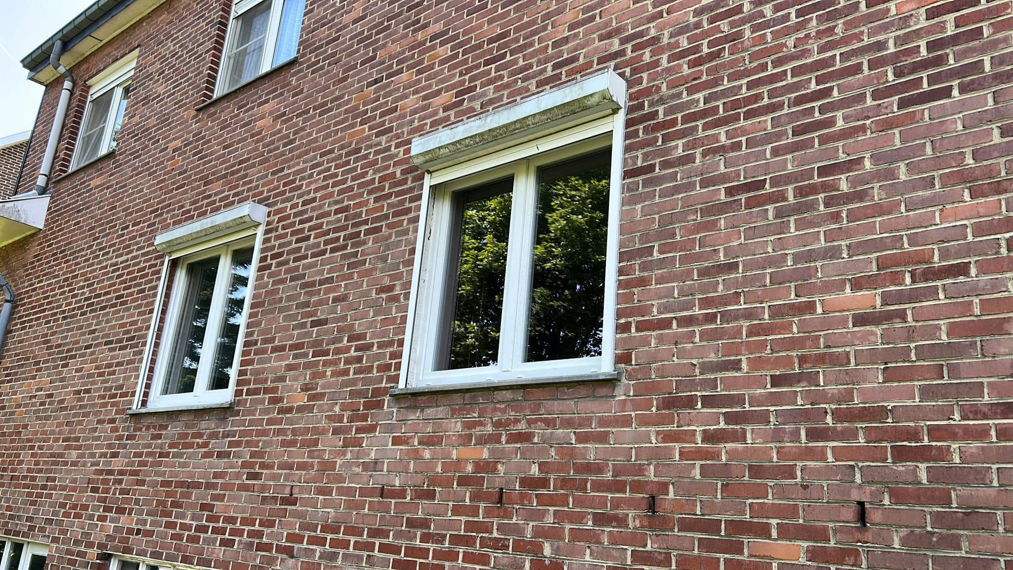 Commerce à Genk : vitrine aluminium et volets solaires